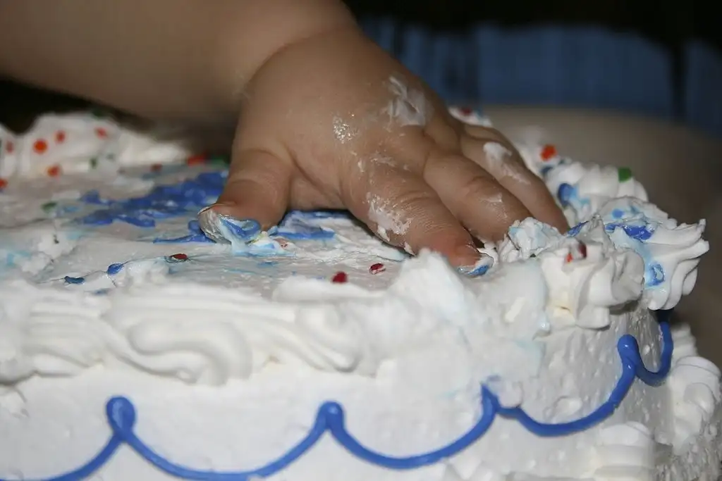 kid destroying gender reveal party cake