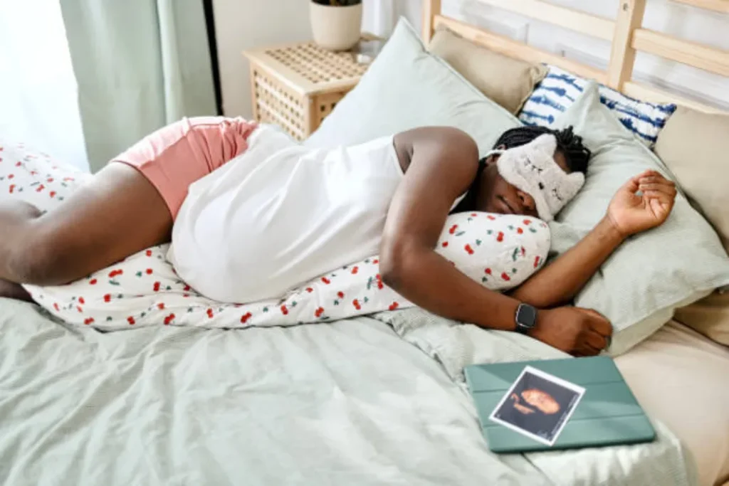 african american female with pregnancy pillow in bed